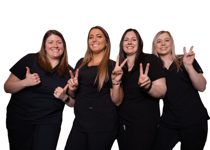 Four of our dental assistants at Hawley Lane Dental smiling while giving thumbs up