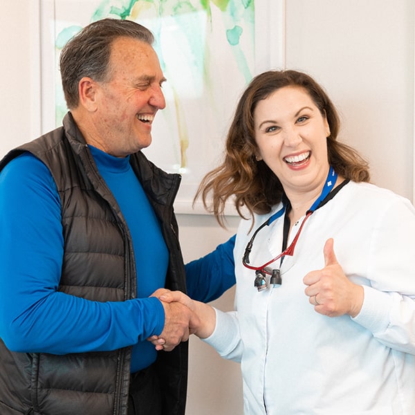 Dr. Kristy Gretzula greeting an older man while giving her thumbs up