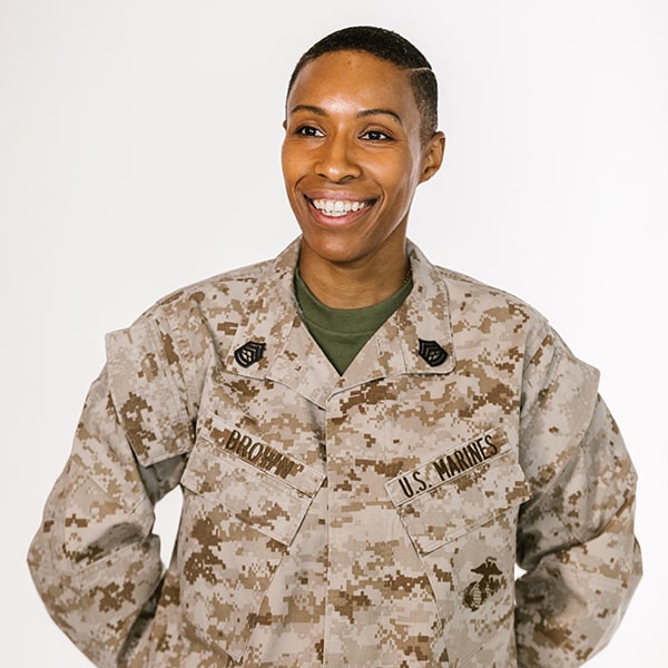 A military woman in her uniform smiling