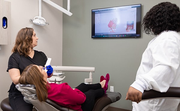 Dr. Kristy Gretzula scanning the mouth of a patient who is lying in the dentist's chair
