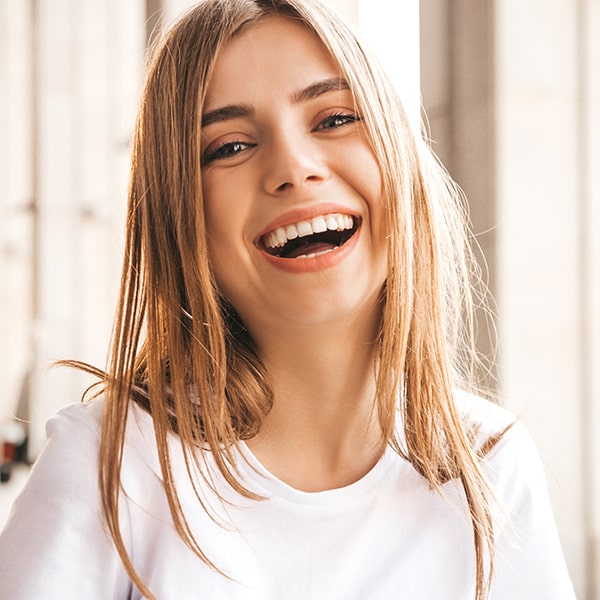 Young woman smiling after her gum treatment